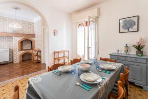 uma sala de jantar com mesa e cadeiras e uma sala com lareira em Villetta Le Ghiande a due passi dalla sabbia em Marina di Mancaversa