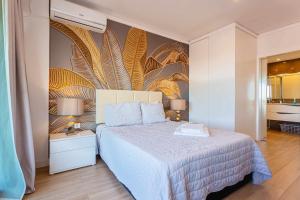 een slaapkamer met een bed en een muurschildering bij Marina View Apartment By VilamouraSun in Vilamoura