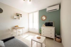 a living room with a couch and a table at Cabana & Le Mimosa Ensoleillé - Plage, Box, Terrasse in Bormes-les-Mimosas