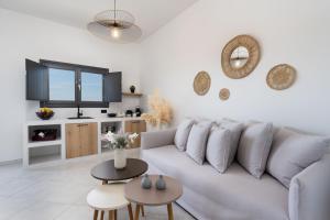 a white living room with a couch and tables at Almira Luxury Suites in Perivolos