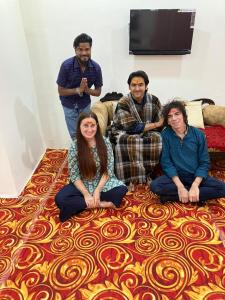 un grupo de personas sentadas en el suelo en una sala de estar en Karma Hostel, en Khajurāho