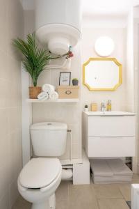 a white bathroom with a toilet and a sink at Cabana & Le Mimosa Ensoleillé - Plage, Box, Terrasse in Bormes-les-Mimosas