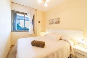 una camera da letto con un grande letto bianco e una finestra di Mediterranean Way - El Mirador a Salou