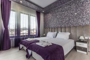 OborishteにあるНиконелの紫色の壁とカーテンが特徴のベッドルーム1室(ベッド2台付)
