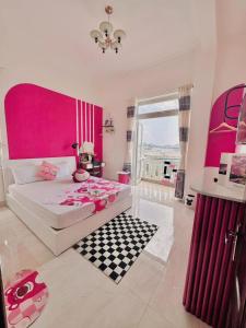 a pink bedroom with a bed and a checkered floor at Bear Brick Villa in Da Lat