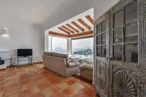 a living room with a couch and a tv at BAHÍA DE EL PORTET - By Almarina Villas in Moraira