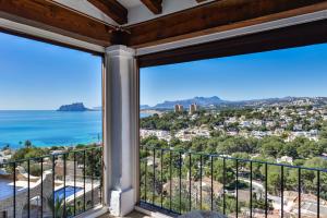 a room with a balcony with a view of the ocean at BAHÍA DE EL PORTET - By Almarina Villas in Moraira