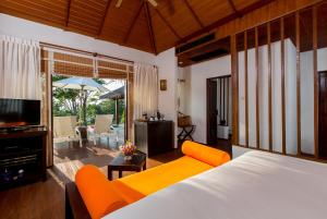 a bedroom with a bed and a living room at Elixir Resort Koh Yao Yai - SHA Plus in Ko Yao Yai