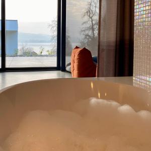 a bath tub in a room with a window at Orange Lounge in Weyregg