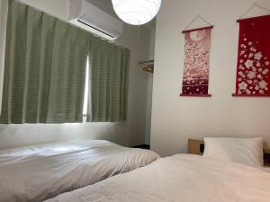 um quarto com duas camas e uma janela com aversão em 西日置 一軒家 rashiku em Nagoia