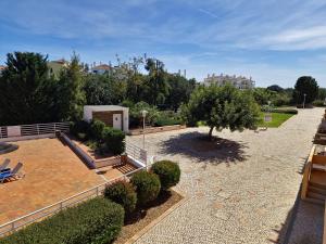 un jardín con un banco y árboles y arbustos en Apartamento Royal Garden T2 by YHA en Conceição