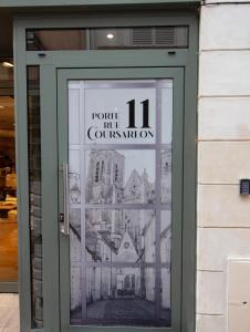 a door to a restaurant with a drawing on it at LE COURSARLON in Bourges