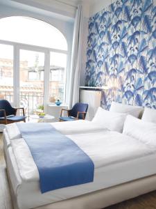 Schlafzimmer mit einem großen Bett mit blauer und weißer Bettwäsche in der Unterkunft Fritz im Pyjama in Hamburg