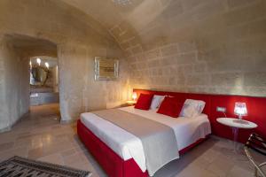 a bedroom with a large bed with red pillows at L'Antica Conceria in Matera