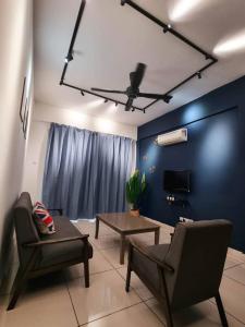 a living room with two chairs and a table and a ceiling fan at Taiping Centre Point Suite 10 by BWC in Taiping