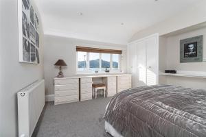 a bedroom with a bed and a desk and a window at Walton House in Conwy