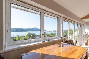 a dining room with a table and large windows at Walton House in Conwy