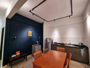 a dining room with a table and a kitchen at Taiping Centre Point Suite 10 by BWC in Taiping