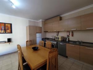 a kitchen with a wooden table and a dining room at 4B Alto dos Navegantes - Casas & Papéis in Armação de Pêra