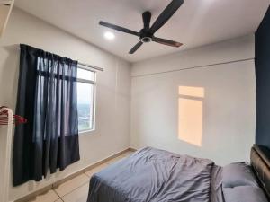 a bedroom with a ceiling fan and a window at Taiping Centre Point Suite 10 by BWC in Taiping