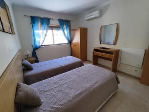 a hotel room with two beds and a mirror at 4B Alto dos Navegantes - Casas & Papéis in Armação de Pêra +13 photos