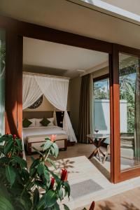 a hotel room with a bed and a large window at Stanagiri Luxury Retreat Ubud in Tegalalang