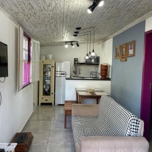 ein Wohnzimmer mit einem Sofa und einem Tisch in der Unterkunft Aconchego de Tiradentes in Tiradentes