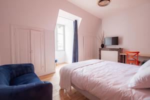 a bedroom with a bed and a blue chair at LE COURSARLON in Bourges