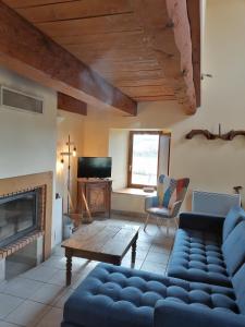 a living room with a couch and a fireplace at Les Gîtes du Clos in La Tour-dʼAuvergne