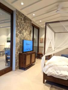 sypialnia z łóżkiem i telewizorem w obiekcie Cape House - Presidential Suite w mieście Amritsar