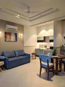 a living room with a blue couch and a table at Cape House - Presidential Suite in Amritsar