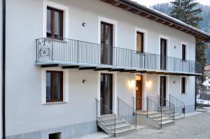 uma casa branca com escadas e uma varanda em Case Verdi em Bardonecchia