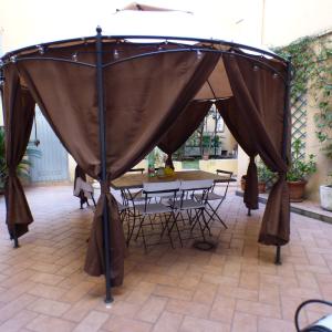 a tent in a patio with a table and chairs at Rose in Tirrenia