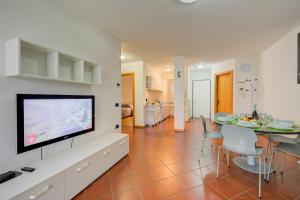 uma sala de estar com televisão e uma sala de jantar em Casa Karin - Happy Rentals em Riva del Garda