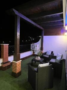 ein Wohnzimmer mit Sofas und einen Balkon mit einem TV in der Unterkunft MARAVILLOSO DUPLEX EN ÍTRABO in Ítrabo