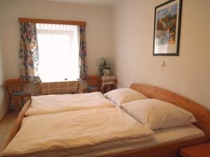 ein großes Bett in einem Schlafzimmer mit Fenster in der Unterkunft Frühstückspension Kammerer in Kleinpöchlarn