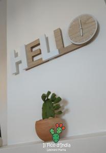 a shelf with a clock and a cactus on a wall at Il Fico d'India in Leporano Marina