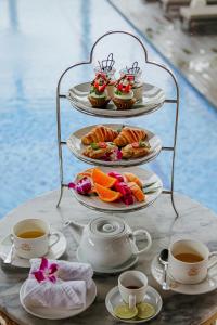 a table with plates of food and cups of coffee at Paris Deli Danang Beach Hotel in Danang