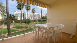 a balcony with a table and chairs and a large window at La riviera VYB in Denia