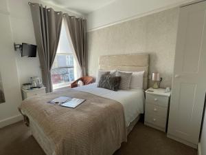 a bedroom with a large bed and a window at Lynton House in Llandudno