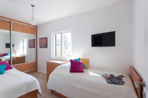 1 dormitorio con 2 camas y TV en la pared en Sweet Dream Apartment, en Dubrovnik