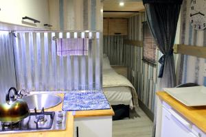 una cocina con fregadero y una cama en una habitación en Ndlovu Tiny Home Dinokeng, en Klipdrift