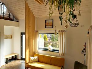 - un salon avec un canapé jaune et une fenêtre dans l'établissement LOFT WAPITI, à Hutisko