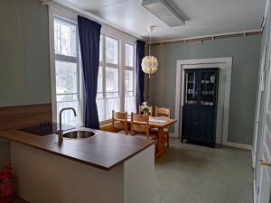 Perrongen Guesthouse في Munkfors: مطبخ مع حوض وغرفة طعام مع طاولة