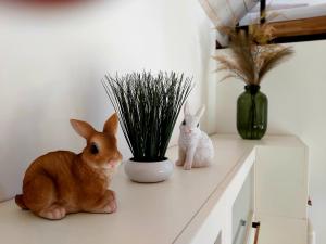 dwa króliki siedzące na ladzie obok rośliny w obiekcie LOFT WAPITI w mieście Hutisko