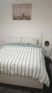 a white bed with green and white pillows on it at Immaculate 1-Bed Apartment in Hinckley in Hinckley