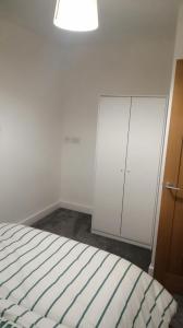 a bedroom with a bed and a white cabinet at Immaculate 1-Bed Apartment in Hinckley in Hinckley