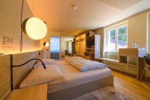 a bedroom with a bed with a lamp and a window at Landhotel Linde Fislisbach in Baden