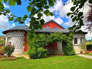 a red and white house with a green yard at Casa Rural Entrepinos in Avila
