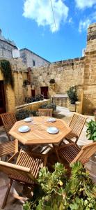 una mesa de madera con dos sillas y un asterisco en Il Mithna farmhouse with indoor heated jacuzzi pool en Għarb
